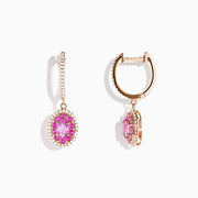 The 14K Rose Gold Pink Sapphire and Diamond Earrings feature oval pink sapphires encircled by diamonds, each suspended from a diamond-studded hook, displayed on a white background.