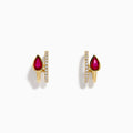 The Ruby Royale 14K Yellow Gold Ruby and Diamond Earrings feature teardrop-shaped red gemstones next to vertical rows of small diamonds, shown on a white background.