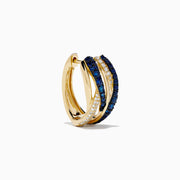 The 14K Yellow Gold Sapphire and Diamond Crossover Hoop Earrings feature intertwined bands set with blue sapphires and small clear diamonds, shown against a white background.