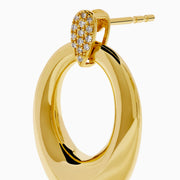 The 14K Yellow Gold Sculptural Diamond Accented Drop Earrings feature a teardrop outline and diamond accents at the top where they attach to the ear.