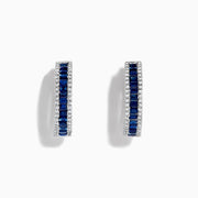 The Royale Bleu 14K White Gold Blue Sapphire and Diamond Hoop Earrings feature a central row of rectangular blue sapphires bordered by round white diamonds, displayed on a white background.