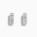 A pair of Lab Grown Emerald Cut Diamond Huggie Earrings in 14K white gold, each featuring three vertically-set rectangular clear stones, is displayed against a plain white background.