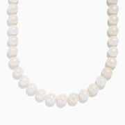 A close-up of the 14K Yellow Gold Fresh Water Pearl Necklace shows large, round freshwater pearls strung on 14K yellow gold, beautifully curved against a plain white background.