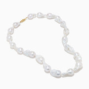 A close-up of the 14K Yellow Gold Freshwater Baroque Pearl Necklace featuring irregularly shaped white pearls and a 14K yellow gold clasp, set against a white background.