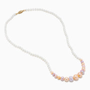 The 14K Yellow Gold Multi Color Freshwater Pearl Necklace features small white pearls graduating to larger pastel pink, peach, and lavender pearls at the center, all elegantly strung on 14K yellow gold.
