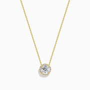 The Star Lab Grown Diamond Halo Pendant in 18K Yellow Gold features a round brilliant lab diamond surrounded by smaller diamonds on a gold chain, displayed against a plain white background.
