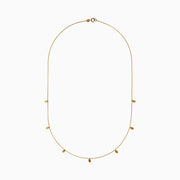 The 14K Yellow Gold Oval Charm Station Necklace features small, evenly spaced oval-shaped charms that hang gracefully along the lower half of a delicate yellow gold chain.