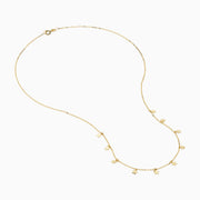 The 14K Yellow Gold Necklace with Star Charms on Chain features a fine gold chain with small star charms evenly spaced along the lower half and is secured with a simple lobster clasp.