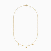 The 14K Yellow Gold Butterfly Station Necklace features three butterfly charms and four round beads evenly spaced along a delicate chain.