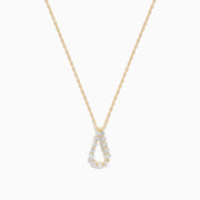 The DOro 14K Yellow Gold Diamond Pendant features a teardrop-shaped diamond accented with sparkling white stones, hanging on a delicate gold chain and set against a plain white background.