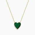 The 14K Gold Malachite and Diamond Reversible Heart Necklace showcases a large, heart-shaped malachite pendant with a smooth finish and delicate gold border.
