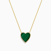 The 14K Gold Malachite and Diamond Reversible Heart Necklace showcases a large, heart-shaped malachite pendant with a smooth finish and delicate gold border.