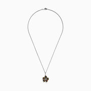 The Splash Sterling Silver Diamond, Sapphires & Tsavorite Flower Necklace features a silver chain with a flower pendant edged in gold, adorned with vibrant sapphires and tsavorite on each petal, and a sparkling diamond at the center.
