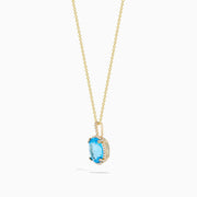 The Ocean Bleu 14K Yellow Gold Blue Topaz and Diamond Pendant features an oval blue topaz surrounded by sparkling diamonds on a gold chain, displayed against a white background.