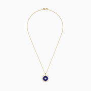 The Seaside 14K Yellow Gold Lapis and Diamond Compass Pendant features a gold chain and round lapis blue pendant with a white starburst design, accented by small gold beads, evoking a compass style. Shown on a plain white background.