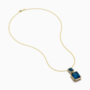 The 14K Yellow Gold London Blue Topaz and Diamond Pendant features two rectangular topaz stones—one accented with diamonds—suspended vertically from a fine gold chain.