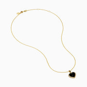 The 14K Yellow Gold Onyx and Diamond Heart Pendant features a glossy black onyx center surrounded by sparkling diamonds, all set on a yellow gold chain necklace.