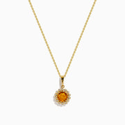 The 14K Yellow Gold Citrine and Diamond Halo Pendant features a round citrine center with a diamond halo, set on a gold chain and displayed against a white background.