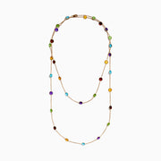 The 14K Rose Gold Multi Color Gemstone Station Necklace features evenly spaced oval gemstones in blue, green, purple, yellow, and red, shown against a white background.
