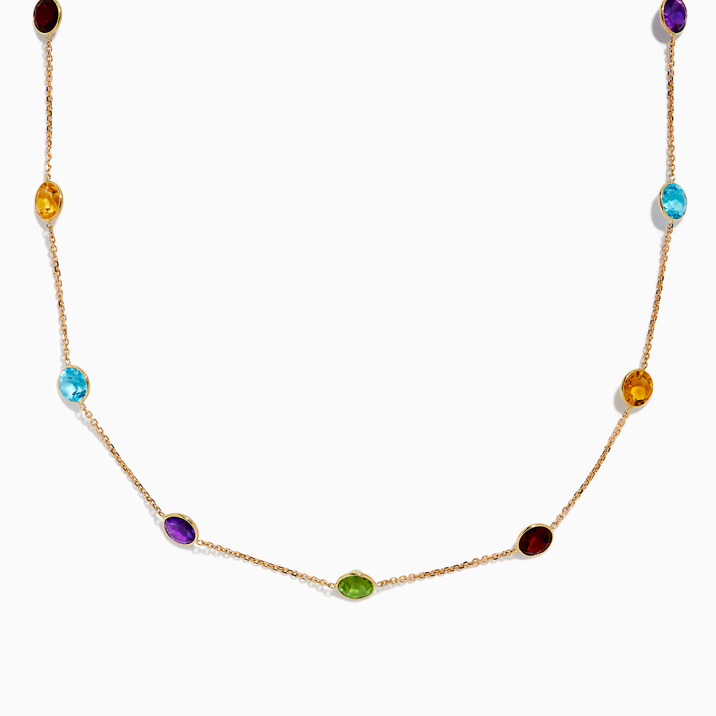 The 14K Rose Gold Multi Color Gemstone Station Necklace features evenly spaced oval gemstones in blue, green, purple, yellow, and red, shown against a white background.