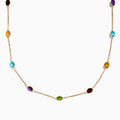The 14K Rose Gold Multi Color Gemstone Station Necklace features evenly spaced oval gemstones in blue, green, purple, yellow, and red, shown against a white background.