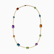 The 14K Yellow Gold Multi-Gemstone Mixed-Shape Station Necklace features seven bezel-set, faceted gemstones in vibrant orange, blue, green, and purple hues, elegantly spaced along the chain.