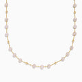 The 14K Yellow Gold Pink Freshwater Pearl Necklace features delicate pink pearls evenly spaced on a yellow gold chain, each pearl separated by small gold beads, and is showcased against a crisp white background.