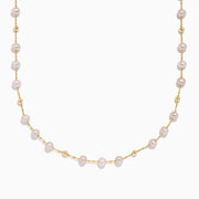 The 14K Yellow Gold Pink Freshwater Pearl Necklace features delicate pink pearls evenly spaced on a yellow gold chain, each pearl separated by small gold beads, and is showcased against a crisp white background.