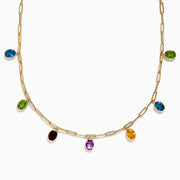 The Mosaic 14K Yellow Gold Multi Gemstone Charm Necklace features oval-shaped charms in blue, green, yellow, purple, and brown gemstones evenly spaced on a yellow gold chain.