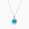 The 14K White Gold Blue Topaz and Diamond Pendant features a square-cut blue topaz accented by a halo of sparkling diamonds, all suspended from a delicate chain.