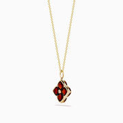 The 14K Yellow Gold Garnet and Diamond Pendant features a four-petal flower-shaped garnet with deep red gemstones outlined in yellow gold and a small clear diamond at the center, shown on a white background.