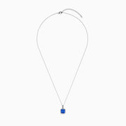 The Nahla Siri 14K Gold Tanzanite and Diamond Pendant features a square blue tanzanite gemstone surrounded by sparkling diamonds, displayed against a white background.