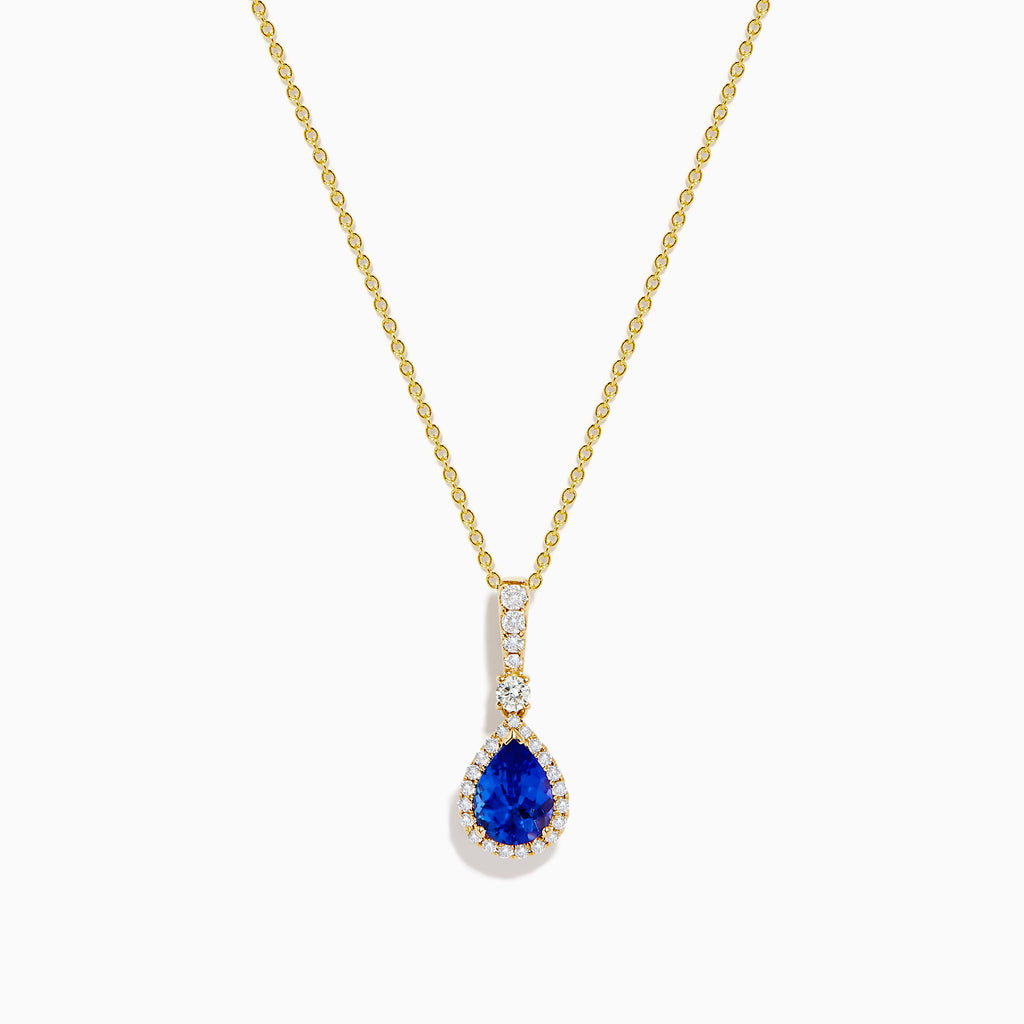 The Nahla 14K Yellow Gold Tanzanite Pendant features a teardrop blue tanzanite surrounded by diamonds and a diamond-accented bail, gleaming at the center of this elegant necklace.