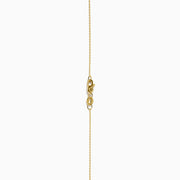The Nahla 14K Yellow Gold Tanzanite Pendant features a teardrop blue tanzanite surrounded by diamonds and a diamond-accented bail, gleaming at the center of this elegant necklace.