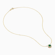 The Brasilica 14K Yellow Gold Emerald and Diamond Necklace features a round green emerald pendant with sparkling diamonds in a flower shape, set in white metal on a delicate gold chain.