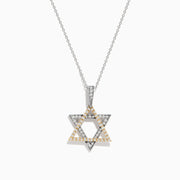 The Novelty 14K Two-Tone Gold Diamond Star of David Pendant, adorned with silver and gold stones, hangs from a delicate chain against a plain white background.