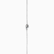 The 18K Two-Tone Gold Green and White Diamond Halo Necklace features a square pendant with a central green gemstone, accented by a double halo of sparkling white diamonds on a delicate chain.