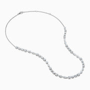 The Lab Grown Multi Shape Diamond 7.25ct Tennis Necklace in 14K White Gold features round, marquise, and emerald cut lab-grown diamonds arranged evenly along the chain and is shown gracefully curved on a white background.