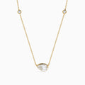 The Lab Grown Diamond Pear Station Necklace in 14K Yellow Gold features a large pear-shaped lab diamond pendant and two small round lab diamonds set along a delicate gold chain.