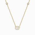 The Lab Grown Diamond Oval Station Necklace in 14K Yellow Gold features a central oval-shaped diamond pendant and two small round diamonds set along each side of the chain, creating an elegant, delicate look.