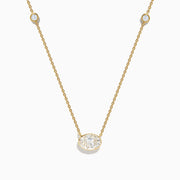 The Lab Grown Diamond Oval Station Necklace in 14K Yellow Gold features a central oval-shaped diamond pendant and two small round diamonds set along each side of the chain, creating an elegant, delicate look.