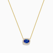 The Nahla 14K White Gold Tanzanite and Diamond Halo Necklace features a central blue oval tanzanite gemstone encircled by diamonds, shown on a white background.