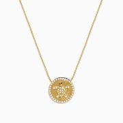 The Seaside 14K Yellow Gold White and Black Diamond Turtle Necklace features a round pendant with a turtle design outlined in sparkling white stones and an accented edge, perfect for adding everyday elegance.