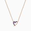 The 14K Rose Gold Pink Sapphire Open Heart Necklace features a delicate heart design, half adorned with sparkling pink sapphires, hanging gracefully from a fine chain for a romantic touch.