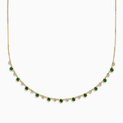 The 14K Yellow Gold Emerald and Diamond Bezel Set Station Necklace features alternating round emeralds and diamonds in bezel settings, evenly spaced along the front curve of the chain, displayed on a white background.