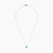 The 18K White Gold Paraiba and Diamond Pendant features a round Paraiba gemstone framed by a halo of white diamonds, elegantly suspended from a fine chain on a white background.