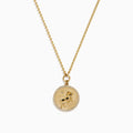 The Zodiac 14K Yellow Gold and Diamond Aries Necklace features a round pendant with an embossed ram, accented by sparkling diamonds, hanging from a delicate gold chain against a white background.