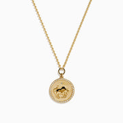 The Zodiac 14K Yellow Gold and Diamond Taurus Necklace features a round pendant with an engraved fish design, accented by diamonds, and hangs from a delicate gold chain on a white background.