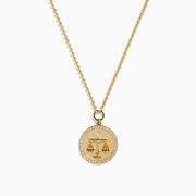 The Zodiac 14K Yellow Gold and Diamond Libra Necklace features a round pendant engraved with the scales of justice, surrounded by sparkling stones for a stunning astrological statement.