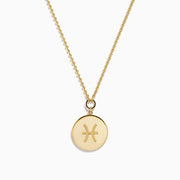 The Zodiac 14K Yellow Gold and Diamond Pisces Necklace features a circular pendant with two embossed dolphins symbolizing Pisces, surrounded by sparkling diamonds for added elegance.